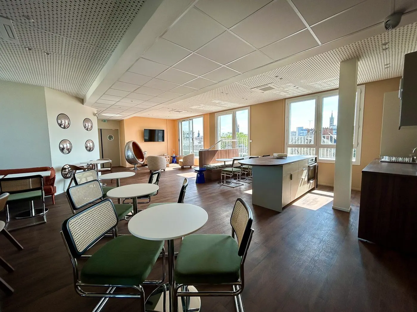 Espace de pause de bureaux vide et net, tables rondes et chaises cannées vertes