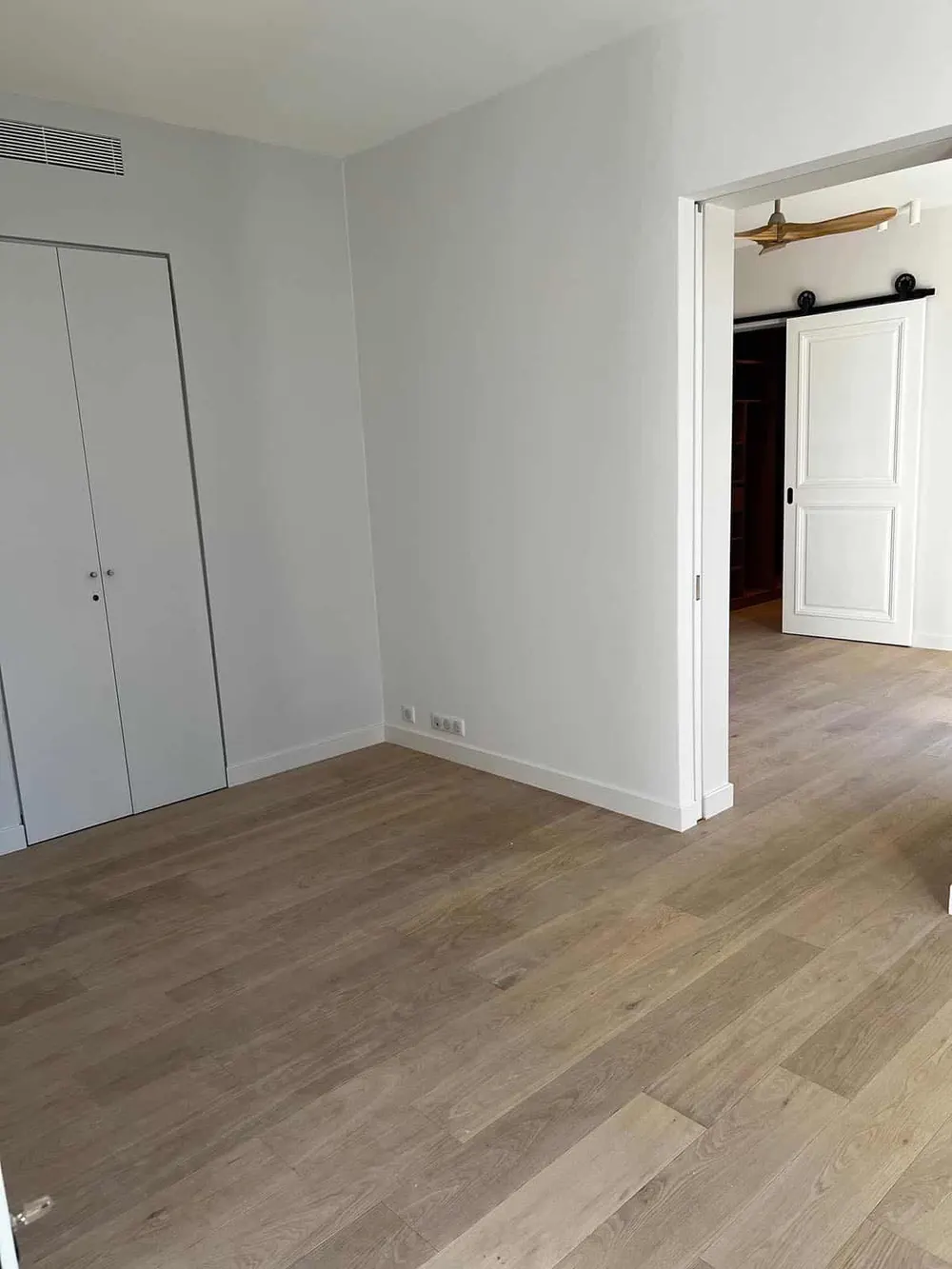 Pièce vide prête à être rendue, parquet de chêne neuf et plinthes blanches